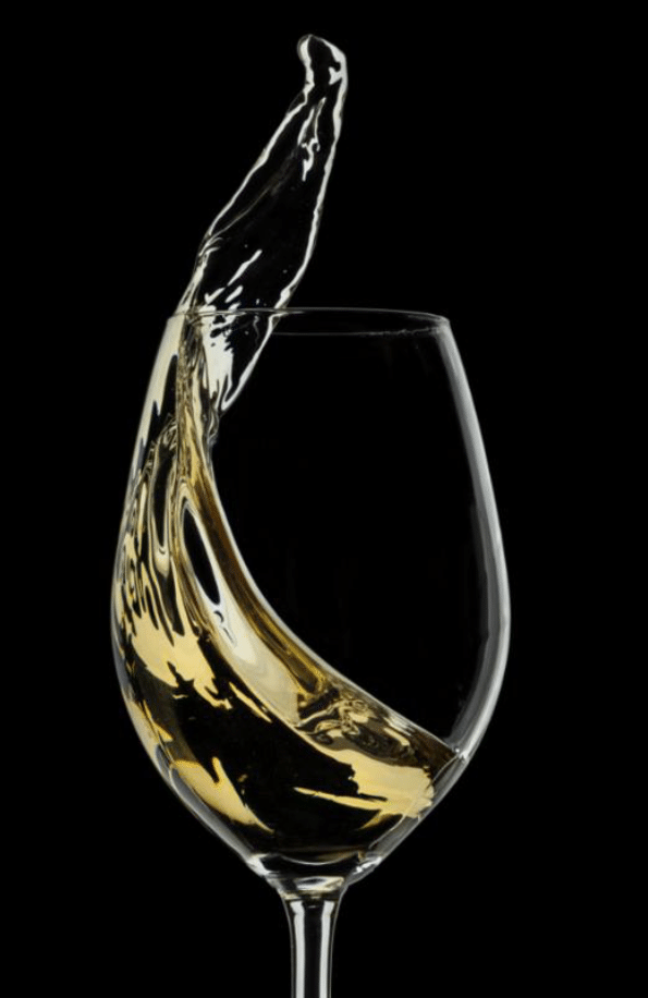 wine glass with white wine being poured in